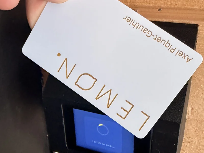 Badge NFC nominatif Lemon gravé au laser passé devant le lecteur, écran « Lecture en cours »